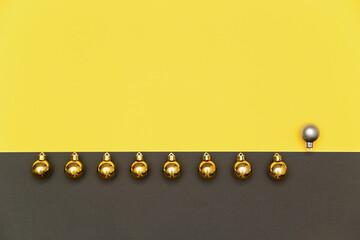 Christmas background in colors of the 2021 year Illuminating and gray. Christmas gold balls and one gray in a line on yellow and gray background.