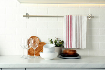 Set of clean tableware on white countertop in kitchen