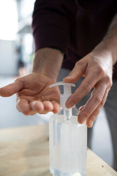 Close-up of man washing hand with sanitizer