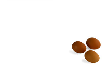 three brown eggs on a white background