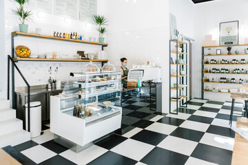 Young woman working while standing at bar counter
