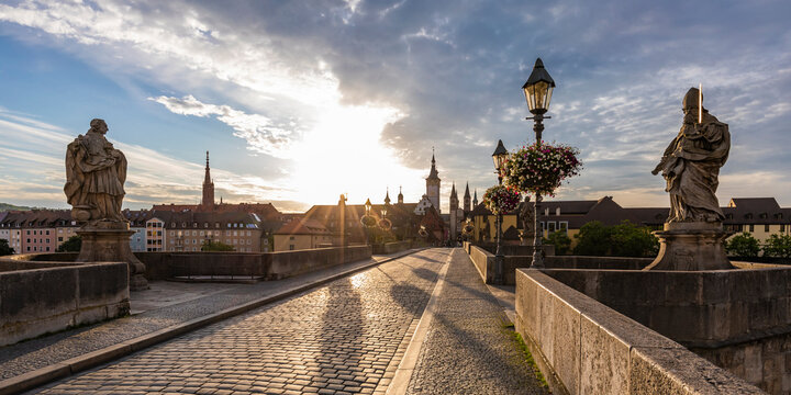 Germany, Bavaria, Wurzburg, Empty Alte Mainbrucke bridge at cloudy sunset