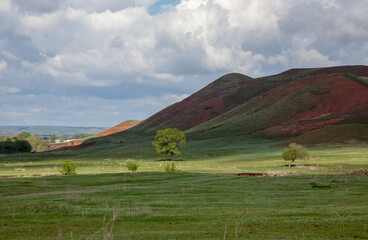 The vastness of Bashkortostan. Hilly terrain, covered with green grass. Bright sunny picture. Lots of free space for insertion.