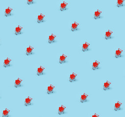 Two red hearts made from paper lay in small shopping cart on blue background. Creative pattern