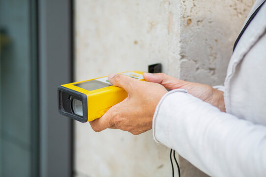 Female architect holding laser distance meter