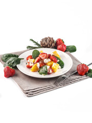 food photography of fresh and healthy salad side view with spinach, roasted pumpkin, strawberry and soft cheese on white background isolated close up