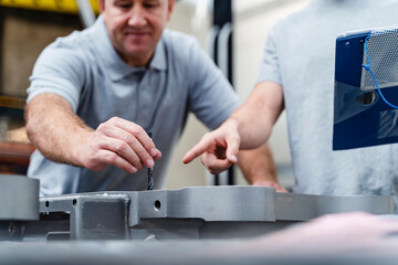 Male employee's hands testing product while analyzing in industry