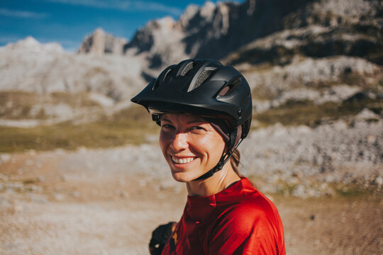 Smiling woman wearing cycling helmet on sunny day, Picos de Europa National Park, Cantabria, Spain