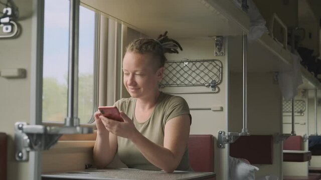 woman passenger rides train and looks out window.