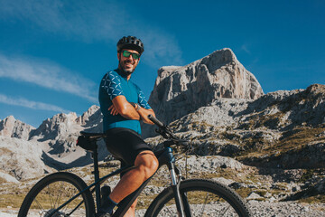 Smiling mountain cyclist with arms crossed at Picos de Europa National Park Cantabria, Spain