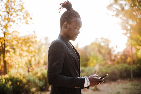 Stylish man using smart phone in park