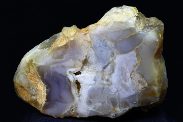 A polished plate of bluish chalcedony against a dark background. Russia
