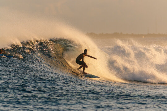 Mid adult man surfing on sea during sunset