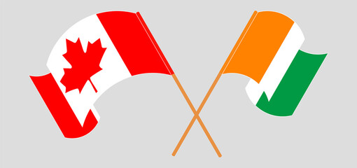 Crossed and waving flags of Canada and Republic of Ivory Coast