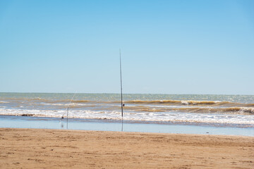 Fishing rods stabbed on the sand waiting for a fish