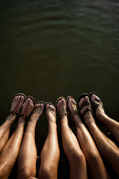 Family legs dangling over lake