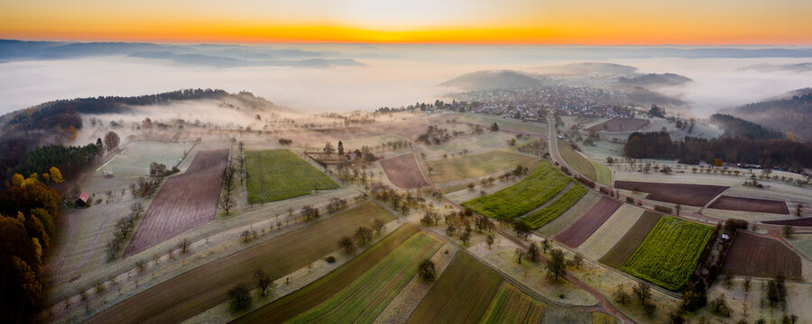 Germany, Baden-Wurttemberg, Berglen, Drone view of countryside fields at foggy autumn sunrise