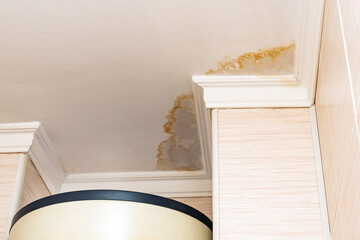 Neighbors have a water leak, water-damaged ceiling, close-up of a stain on the ceiling