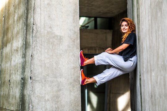 Smiling woman balancing while climbing wall
