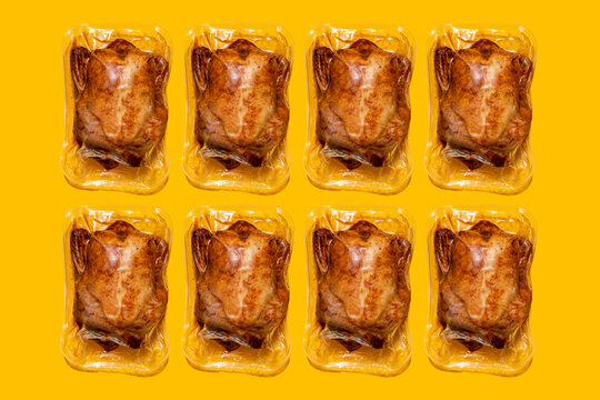 Vacuum Packed Roasted Chickens Arranged In A Row On Yellow Background