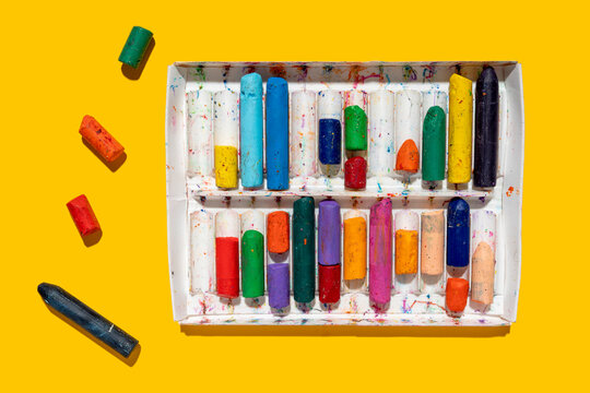 Colorful crayons on yellow background