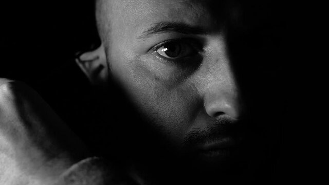 Black and White Close up portrait. 4k, The young man takes off his medical mask.  Isolated on Black background. Health care and medical concept.