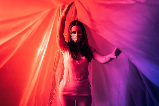 Woman wearing protective face mask covered in plastic during COVID-19