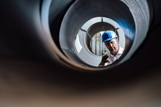 Man scanning barcode on steel rolls in industry
