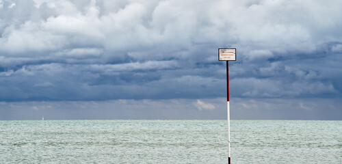 Danger sign at the beach in a cloudy day of September in Caorle