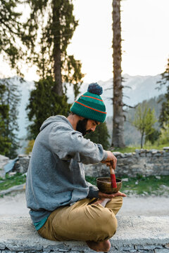 Male hiker playing outdoors on rin gong