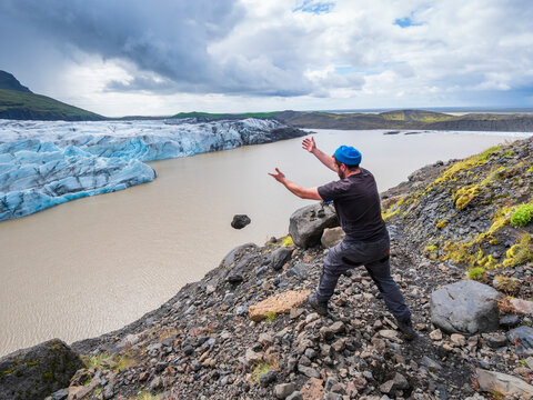 Mid adult man throwing stone in lake at Svinafellsjokull glacier, Iceland