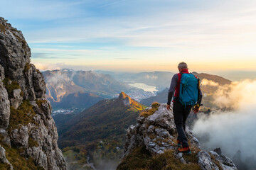 Pensive male hiker walking on mountain peak during sunrise at Bergamasque Alps, Italy
