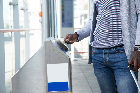 Businessman scanning ticket at gate of railroad station