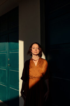 Woman with eyes closed standing by door in resort at Deauville, France