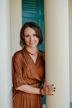 Smiling woman standing by pillar in resort at Deauville, France