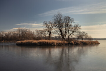 December landscape with a frozen lake and an island