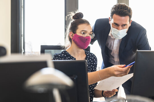 Business People Wearing Face Mask Having Discussion While Working At Office