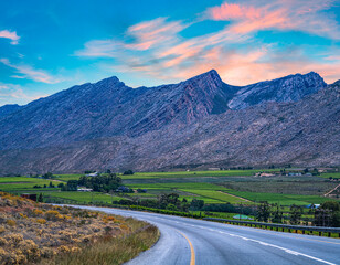 Hex River valley wine farms mountains and N1 with blue sky golden clouds in Western Cape South Africa