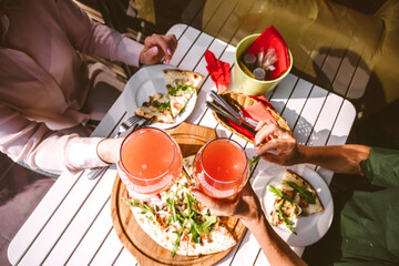 Friends toasting fruit drink while sitting at restaurant