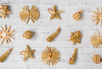 Christmas festive background from straw festive decorations on a light background. Top layout. Pattern.