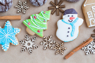 Gingerbread painted colored gingerbread cookies and spices and snowflakes on a craft background close-up. Christmas celebration concept. New Year's food