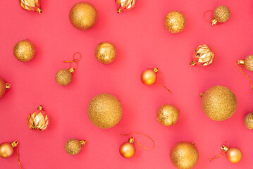 Gold glitter. Christmas balls of different sizes on a pink background pattern. Flat lay, top view