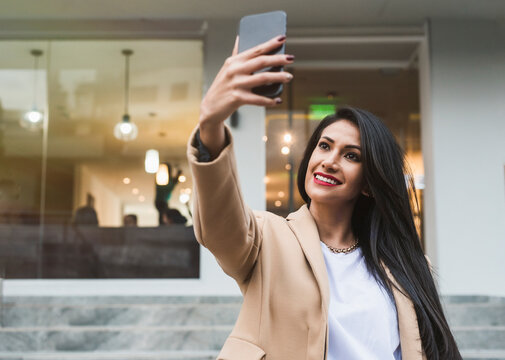Woman taking a selfie with her smartphone in city
