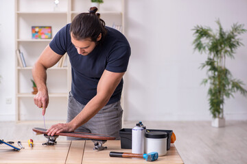 Young male repairman repairing skateboard