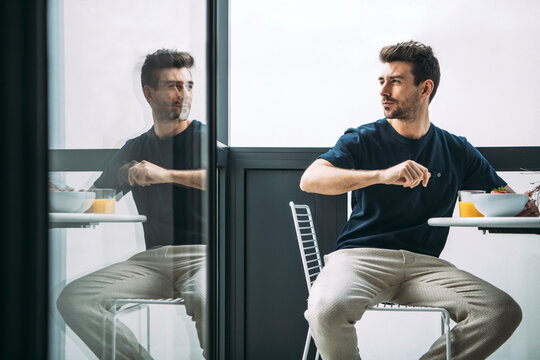 Chilling man on terrace with breakfast meal