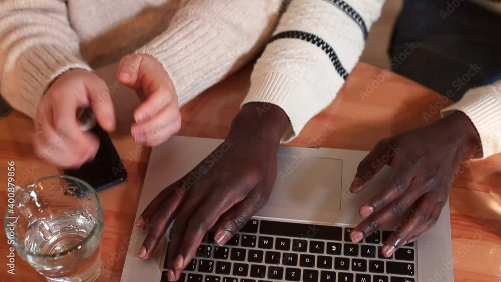 Poster hands of afro and white team workers use the phone with laptop on the table. take photos. decision m