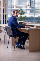 Young male teacher in suit in the classroom