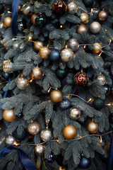 Photo of pretty nice decorated xmas tree with golden silver balls blue ribbon electrical lights