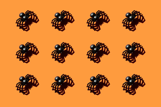 Pattern of black plastic spiders against orange background