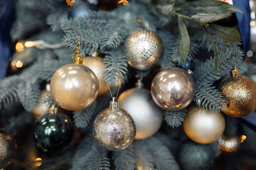 Photo of golden silver balls pretty modern decorations hanging on green xmas tree